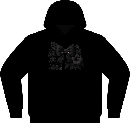 A black pullover hoodie featuring a dark graphic print on the chest of a black bow surrounded by tropical leaves and flowers with tiny pink eyes, shown against a plain white background.