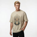 Man wearing a beige t-shirt with the lotus design on a plain background